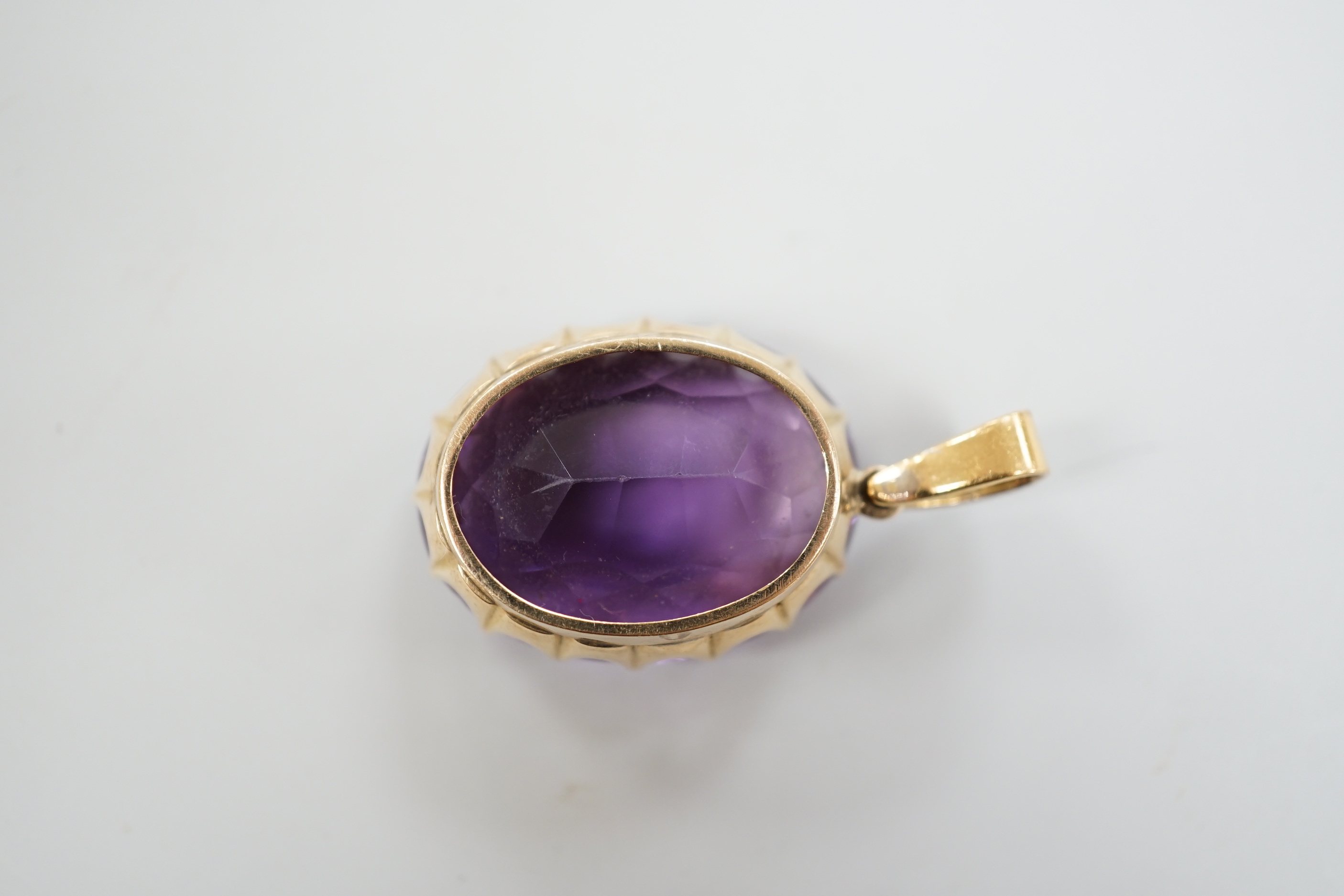 An Edwardian yellow metal, oval cut amethyst and three stone diamond set drop pendant, overall 4cm, gross weight 16.7 grams.